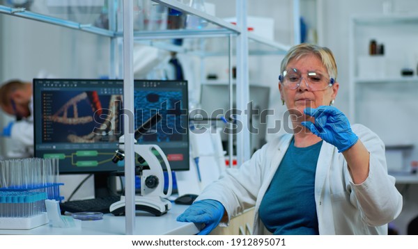 Woman lab technician looking at virus sample\
in modern equipped laboratory. Senior scientist working with\
various bacteria tissue and blood tests, concept of pharmaceutical\
research for antibiotics