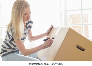 Woman Labeling Moving Box At Home