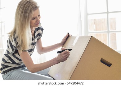 Woman Labeling Moving Box At Home