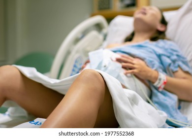 A Woman In Labor, With Painful Contractions, Lying In The Hospital Bed. Childbirth And Baby Delivery.