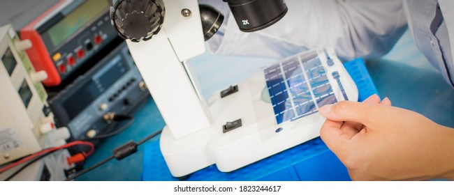 Woman laboratory assistant tests film solar cells