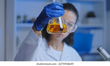 Woman laboratory scientist observing chemical reaction of liquid in flask, experiment - Powered by Shutterstock