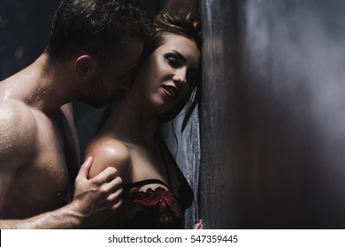 Woman in a lace bra is standing back to man during shower