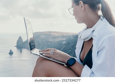 Woman Laptop Beach Working Remotely on Cliffside with Ocean View. - Powered by Shutterstock