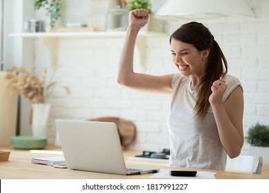 Woman with laptop and calculator excited about finally paying down her mortgage. Young lady super happy about refund approval email. Smiling millennial woman celebrating successful online investment
