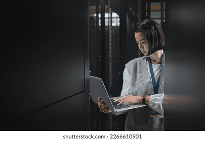 Woman with laptop, datacenter and information technology, engineer and server room with software update. Tech industry, cybersecurity and network with Asian female setting up firewall and database - Powered by Shutterstock