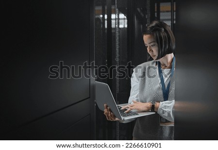 Woman with laptop, datacenter and information technology, engineer and server room with software update. Tech industry, cybersecurity and network with Asian female setting up firewall and database