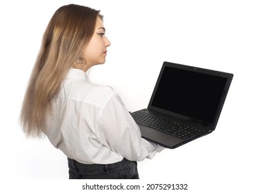 Woman Laptop. Girl Stands With Open Laptop. Computer Is Portable In Hands Of Girl. Notebook Screen Is Off. Businesswoman With Laptop With Her Back To Camera. Place For Software Demonstration.