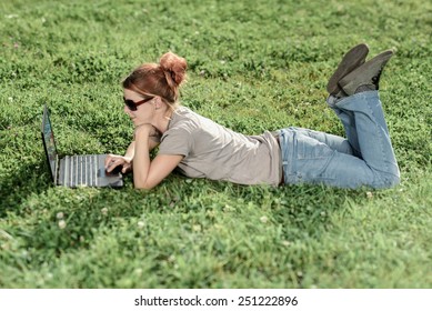 Woman With Laptop Relaxing In Park