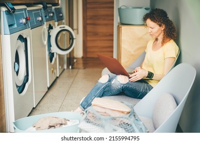 Woman with laptop waiting for laundry.  - Powered by Shutterstock