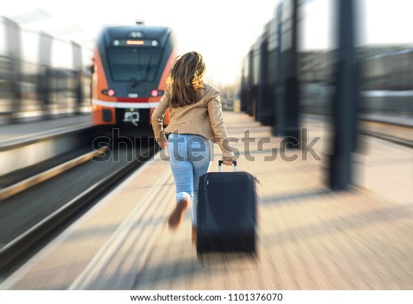 Woman late from train. Tourist running and\
chasing the leaving train in station. Person with stress pulling\
suitcase in platform. Rushing to get\
on.