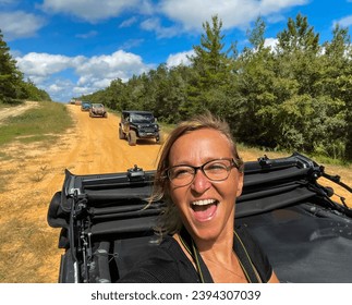Woman laughing from the top of a Jeep while trail riding