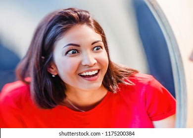 A Woman Laughs And Looks At The Reflection In A Distorted Mirror Room