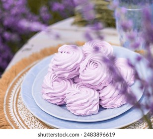 woman in lavender field eating homemade zephyr.marshmallow with flower taste,purple color.girl in dress on picnic table with candles,blue tea as decor.cloudy summer day.hand taking dessert from plate - Powered by Shutterstock