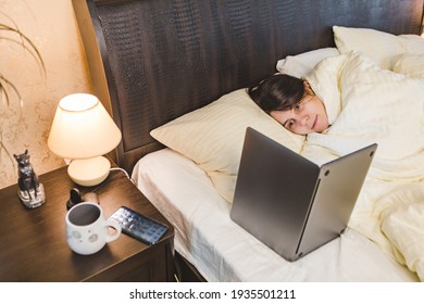 Woman Laying Down In Bed Covered With Blanket Looking Show On Laptop Copy Space