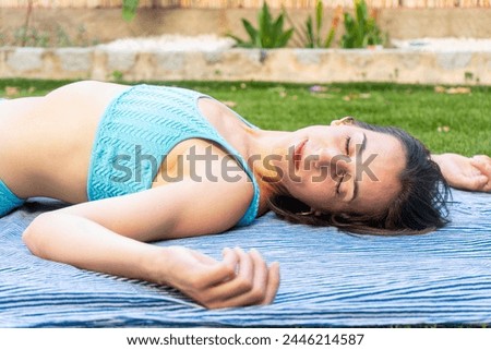 a woman laying on a blue blanket with a blue top