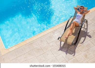 Woman Laying On A Chair Near The Pool