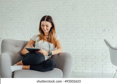 Woman is laying on the couch and using tablet pc - Powered by Shutterstock