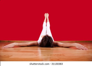 Woman Laying On The Floor Of Her House With Her Legs Up Next To A Red Wall