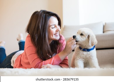 Woman Laying On Floor With A Puppy