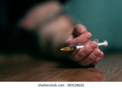 Woman Laying On The Ground With Needle In Hand