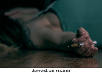 Woman Laying On The Ground With Needle In Hand