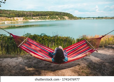 Woman Laying On Hammock Enjoying The View Of Summer Lake