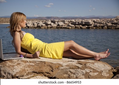 A Woman Laying Out On Vacation Trying To Get Some Sun, But Still Can Not Get Away From Her Computer, She Is Locked And Chained To Work.