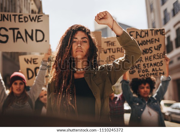 Woman\
leading a group of demonstrators on road. Group of female\
protesting for equality and women\
empowerment.