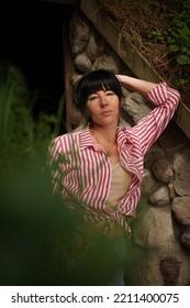 A Woman Leaned Against A Cobblestone Wall Close-up