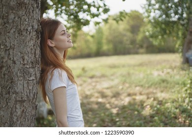 woman leaned her back on a tree in nature                  