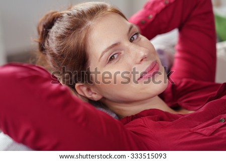 woman leaning back on her sofa while smiling at the camera