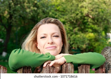 Woman Leaning Over The Fence In The Garden,42 Years