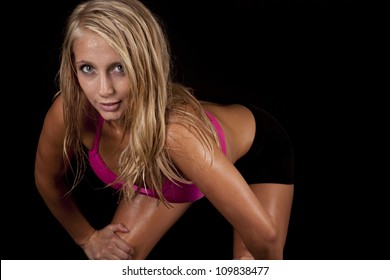 A Woman Leaning Over With An Intense Expression On Her Face With Sweat Dripping Off Of Her Body.