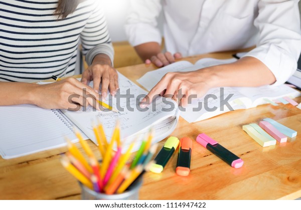 woman learn and teach tutor\
concept education  helping each other sitting in a table at class\
room