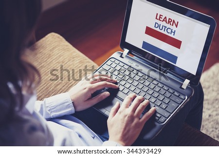 Woman learning dutch through internet with a laptop at home