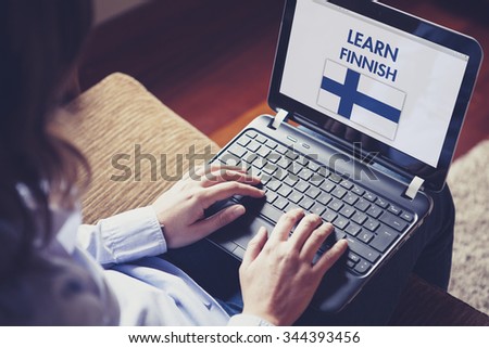 Woman learning Finnish language through internet with a laptop at home
