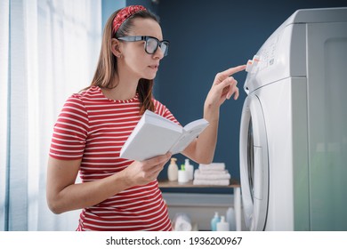 Woman learning how to use her washing machine and fixing problems, she is checking the instructions on the manual