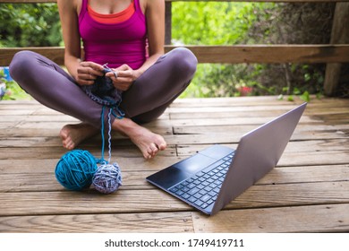 A Woman Is Learning To Knit On Video Lessons From The Internet, The Development Of New Skills, Knitting, Girl Knits While And Watching A Movie On A Laptop, Hobbies During Quarantine.