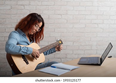 A Woman Is Learning To Play The Guitar Online. Remote Music Lesson