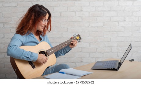 A Woman Is Learning To Play The Guitar Online. Remote Music Lesson