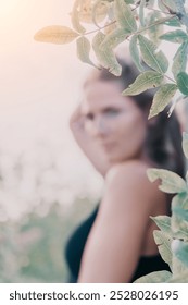 Woman, Leaves, Blurred Portrait - A woman's face is blurred and partially obscured by leaves in an outdoor setting, highlighting the artistry of the blurred effect.