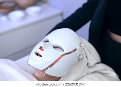 Woman with led light therapy facial and neck beauty mask photon therapy - Powered by Shutterstock