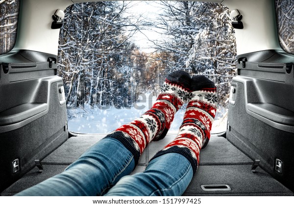 Woman legs with christmas socks and winter time in car\
interior. 