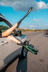 Woman Legs In Flippers Stick Out From The Car Window Sea Vacation Concept Road Trip