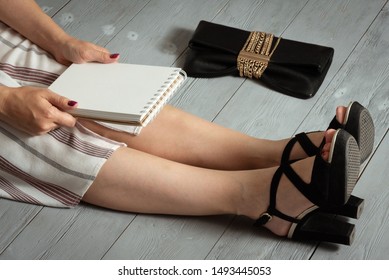 Woman Legs In A High Heels Shoes, Clutch Bag And A Blank Page Notepad. Women Tips. Female Tricks Mock Up. 