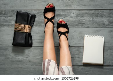 Woman Legs In A High Heels Shoes, Clutch Bag And A Blank Page Notepad. Women Tips. Female Tricks Mock Up. 