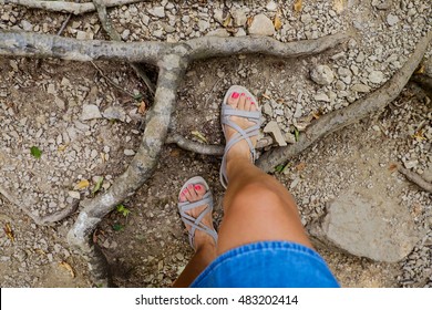 Woman Legs In Hiking Sandals Walking Through The Rocky Mountains Outdoor. Top View. Trekking Shoes On Hiker Girl Feet Crossing Stones Land. Person Nature Travel Concept. Feet Selfie.