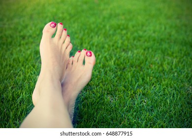 Woman legs on a green grass toned instagram style