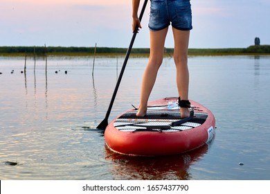 Woman Legs On SUP (stand Up Paddle Board) In Water Of The River